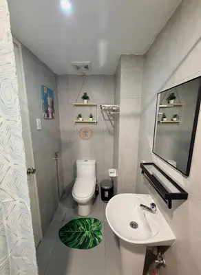 a bathroom with a white toilet and a sink at Cozy African Home in Parañaque in Manila