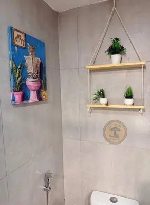 a bathroom with a toilet and some plants on shelves at Cozy African Home in Parañaque in Manila