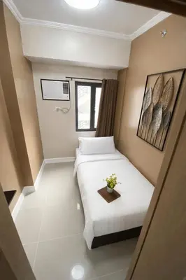 a small room with a bed and a table at 2 BR Fully Furnished Condo in Parañaque with Pool and Parking - Bloom Unit 1134 in Manila