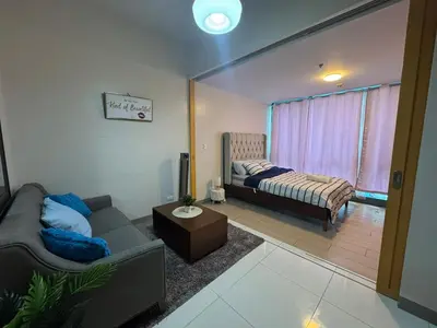 a living room with a couch and a bed at BGC Luxe Condo I Facing Grand Hyatt & Uptown Mall in Manila
