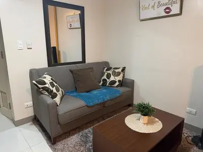 a living room with a couch and a table at BGC Luxe Condo I Facing Grand Hyatt & Uptown Mall in Manila
