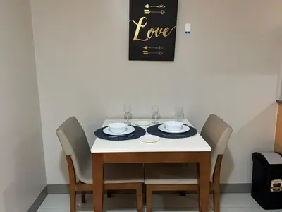 a dining room table with chairs and a plate of food at BGC Luxe Condo I Facing Grand Hyatt & Uptown Mall in Manila