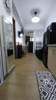 a living room with a hallway with a mirror at MC Staycation at Spring Residences Near Airport in Manila