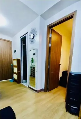 an empty room with a mirror and a clock on the wall at MC Staycation at Spring Residences Near Airport in Manila