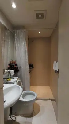 a bathroom with a white toilet and a sink at Upside Down in Manila
