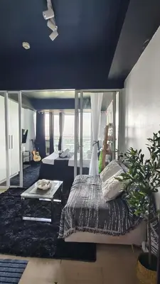 a bedroom with a bed and a table in a room at Upside Down in Manila