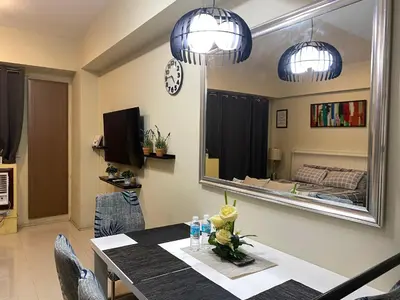 a dining room with a table and a mirror at Theresa Place Like Home in Manila