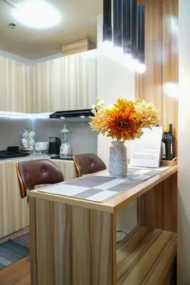 a kitchen with a table with a vase of flowers on it at Cozy Staycation in The Radiance Manila Bay in Manila