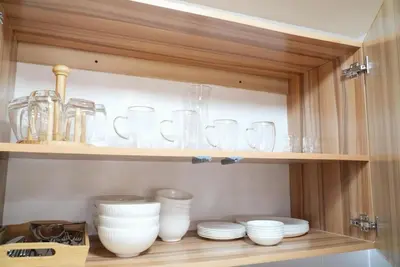 a cabinet filled with glasses and plates and bowls at Cozy Staycation in The Radiance Manila Bay in Manila