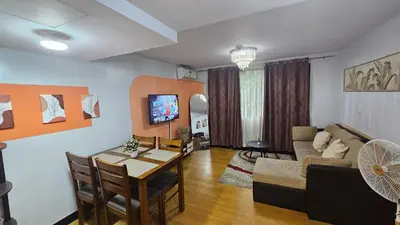 a living room with a table and a dining room at Bright & Airy Loft Cambridge Village Charm in Cainta