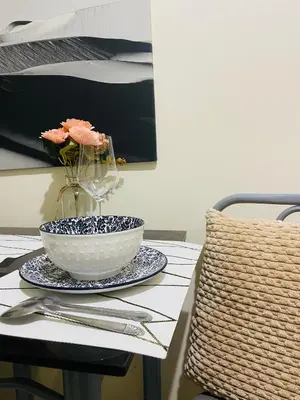 a bowl on a plate on a table with a vase at Haven Suites by Amf in Manila