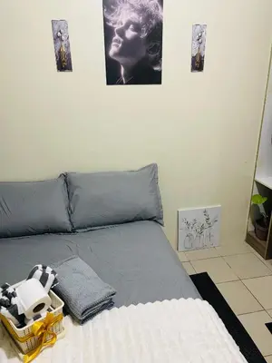 a bed in a room with pictures on the wall at Haven Suites by Amf in Manila