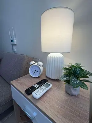 a table with a remote control and a clock and a lamp at Las Fallas Staycation in Santa Rosa