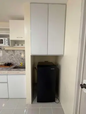 a kitchen with a black refrigerator and white cabinets at Las Fallas Staycation in Santa Rosa