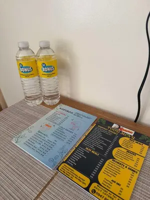 two bottles of water and a menu on a table at Las Fallas Staycation in Santa Rosa