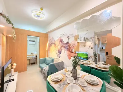 a living room with a table and a room with a painting at Bright Unit at Bloom near NAIA l WiFi Netflix BLOOM B02-0803 in Manila