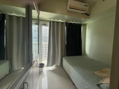a bedroom with a bed and a large window at 1BR Staycation at JAZZ Makati 29F 65 Smart TV in Manila