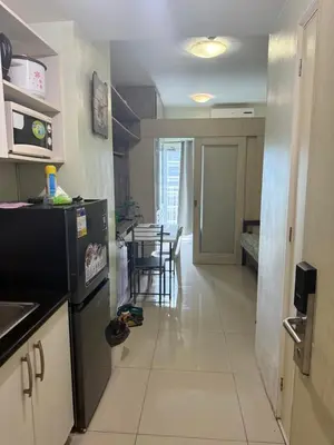 a kitchen and dining room with a table with chairs at 1BR Staycation at JAZZ Makati 29F 65 Smart TV in Manila
