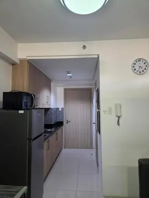 a kitchen with a refrigerator and a clock on the wall at Shore 1 Residences in Manila