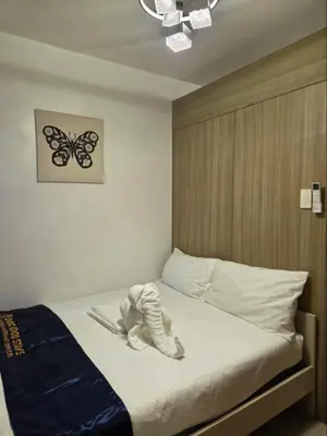 a bedroom with a bed with a butterfly picture on the wall at Shore 1 Residences in Manila