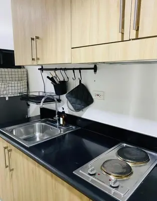 a kitchen counter with a sink and a stove at Shore 1 Residences in Manila