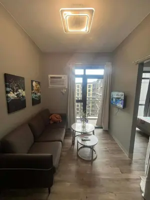 a living room with a couch and a table at Cozy Gentry Manor TV Netflix Seaview near Okada MOA17V in Manila