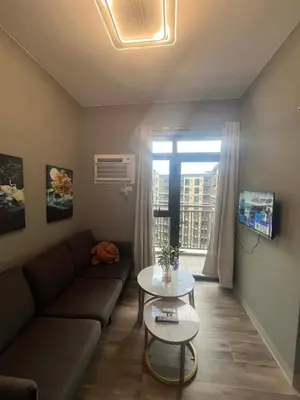 a living room with a couch and a table at Cozy Gentry Manor TV Netflix Seaview near Okada MOA17V in Manila