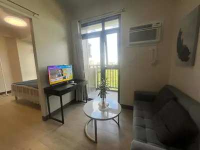 a living room with a couch and a table at Gentry Manor WiFi Netflix&Balcony Near Okada NAIA in Manila