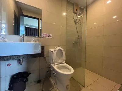 a bathroom with a toilet and a sink and a shower at Gentry Manor WiFi Netflix&Balcony Near Okada NAIA in Manila