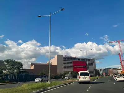 a street with cars driving on a highway with a building at Gentry Manor WiFi Netflix&Balcony Near Okada NAIA in Manila