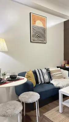 a living room with a blue couch and a table at Air Residences Makati CBD 1BR w Balcony in Manila