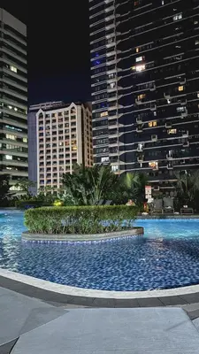 a large swimming pool in a city at night at Air Residences Makati CBD 1BR w Balcony in Manila