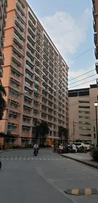 a motorcycle parked in front of a large building at AC's Suite in Manila