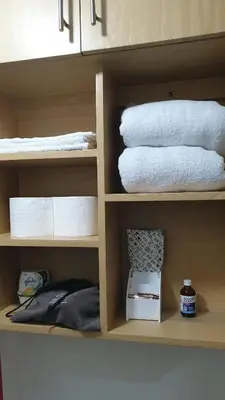 a shelf with towels and other towels on it at AC's Suite in Manila