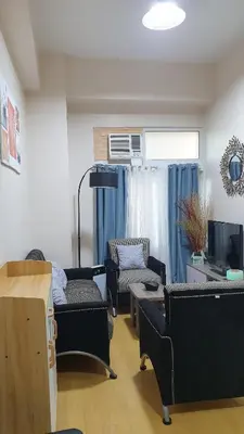 a living room with two couches and a tv at AC's Suite in Manila