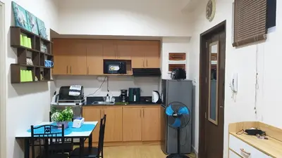 a small kitchen with a table and a refrigerator at AC's Suite in Manila