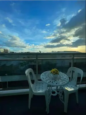 a table and two chairs on a balcony at Azure Resort Condo with Man-Made Beach Pool in Manila