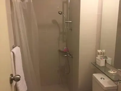 a bathroom with a shower with a glass door at Azure Resort Condo with Man-Made Beach Pool in Manila