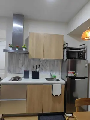 a small kitchen with a sink and a refrigerator at Panatag Staycation by Yani at Azure Urban Residences, Parañaque in Manila