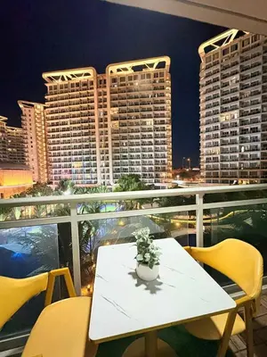 a white table and chairs on a balcony with buildings at Panatag Staycation by Yani at Azure Urban Residences, Parañaque in Manila