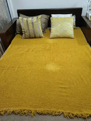 a bed with a yellow blanket and pillows on it at Panatag Staycation by Yani at Azure Urban Residences, Parañaque in Manila