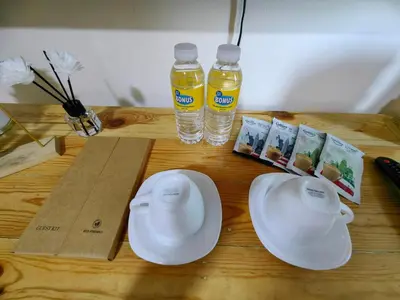a table with two plates and two bottles of water at Panatag Staycation by Yani at Azure Urban Residences, Parañaque in Manila