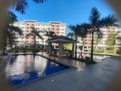 a swimming pool with a gazebo in front of a building at Beirut Bliss Suite at Hope Residences Trece Martires in Trece Martires