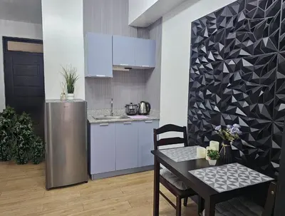 a kitchen with a table and a stainless steel refrigerator at Paseo Verde Las Pinas - Sleeps 2 Adults 2 Children in Manila