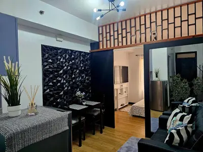 a living room with a table and a kitchen at Paseo Verde Las Pinas - Sleeps 2 Adults 2 Children in Manila