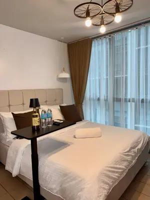 a bedroom with a bed with a table with bottles of water at One uptown Residence,BGC, Manila 1bedroom in Manila