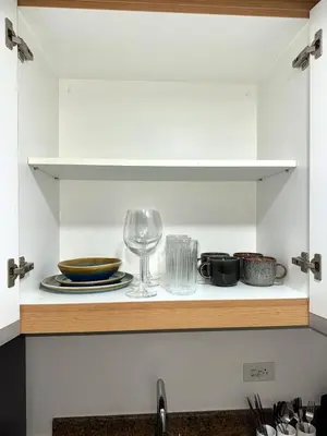 a cupboard with a plate and a wine glass at One uptown Residence,BGC, Manila 1bedroom in Manila