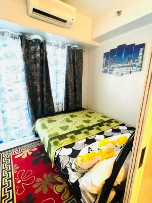 a small bed in a small room with curtains at Sea Residences Elegant Place by Paul in Manila