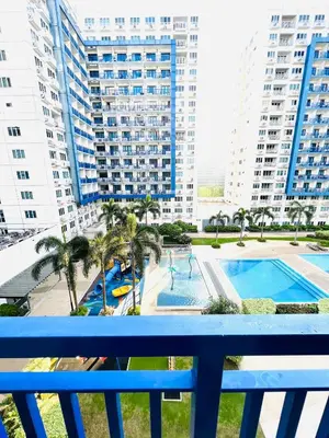 a view of a pool from a balcony with buildings at Sea Residences Elegant Place by Paul in Manila