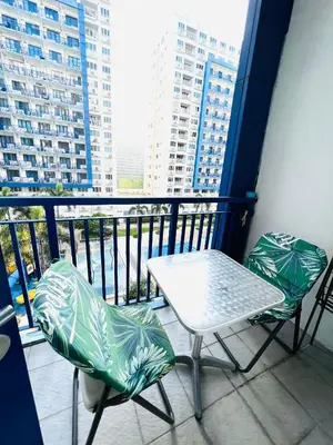 a table and chairs on a balcony with a view at Sea Residences Elegant Place by Paul in Manila